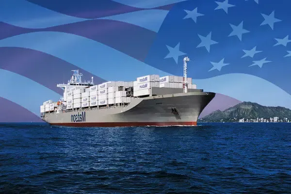 澳门网站游戏电子平台 ship loaded with containers arriving Honolulu with imposed American flag in the background.